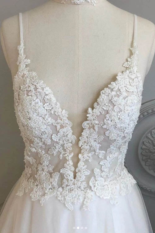 Close-up of lace bodice and spaghetti straps on a beach wedding dress.