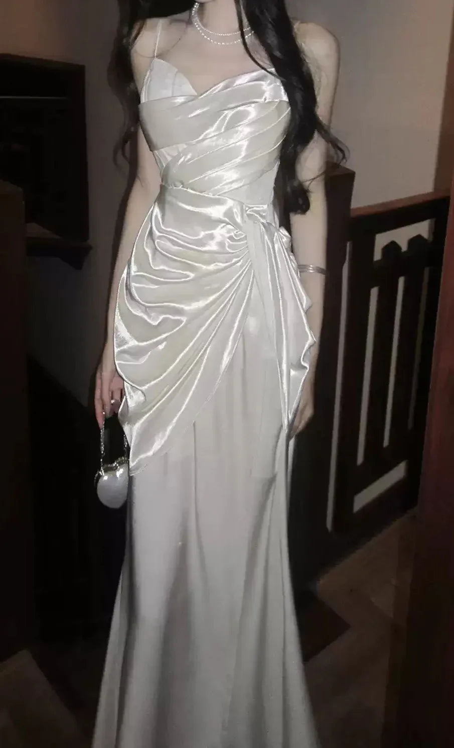 Back view of a white satin ruched mermaid prom dress.