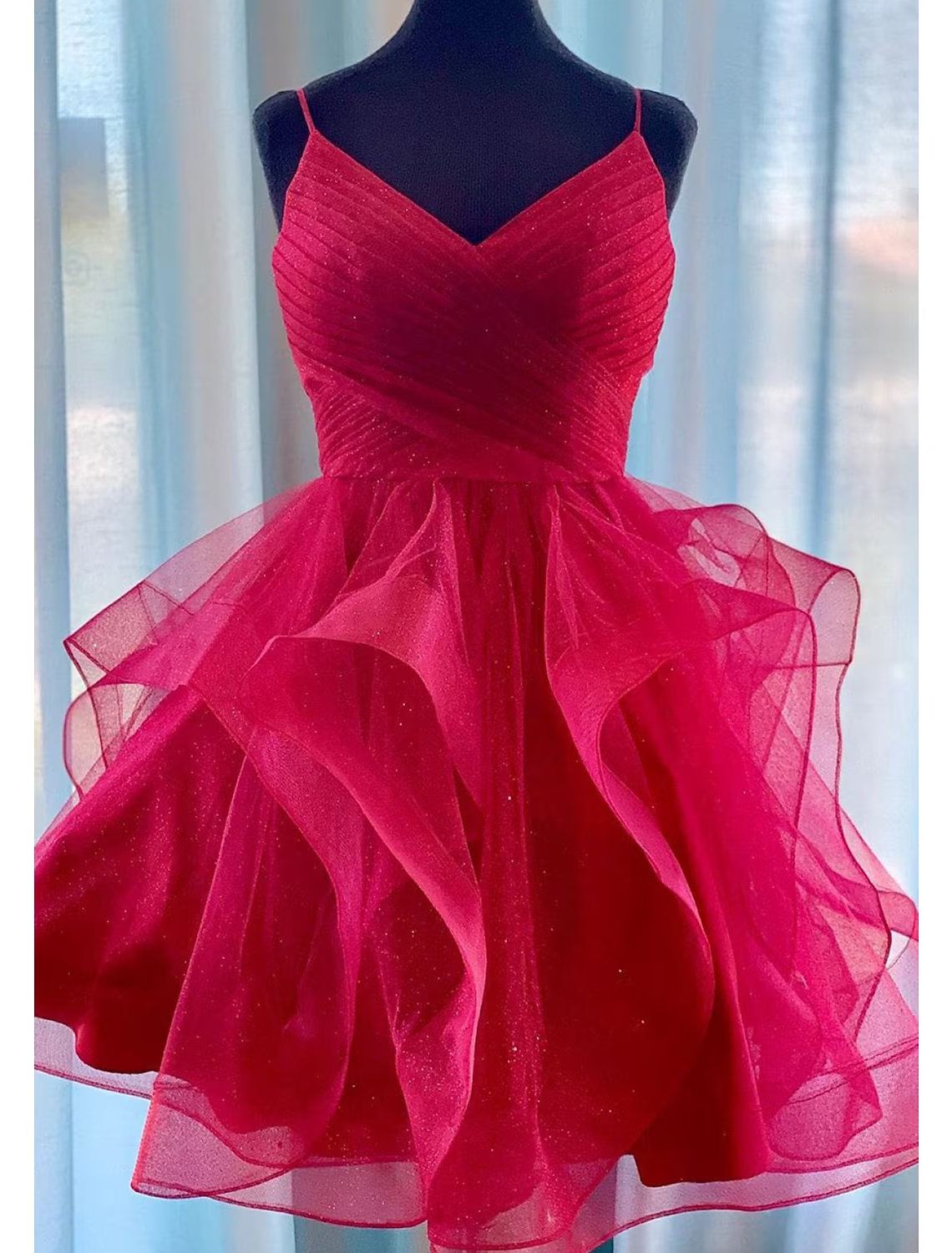Model wearing a pink glittering short ball gown homecoming dress with spaghetti straps.