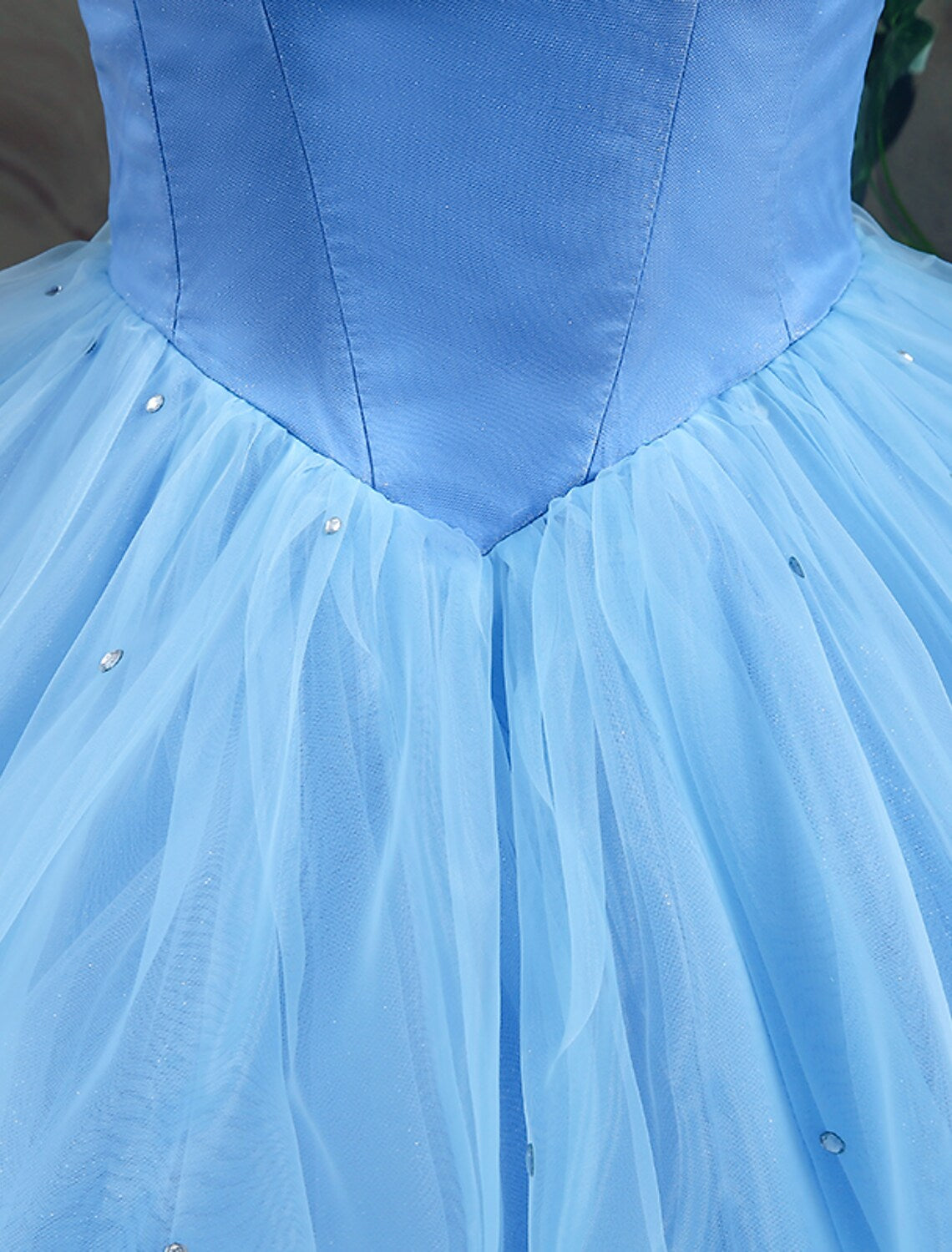 Close-up of the off-shoulder bodice and delicate appliques on a satin ball gown.