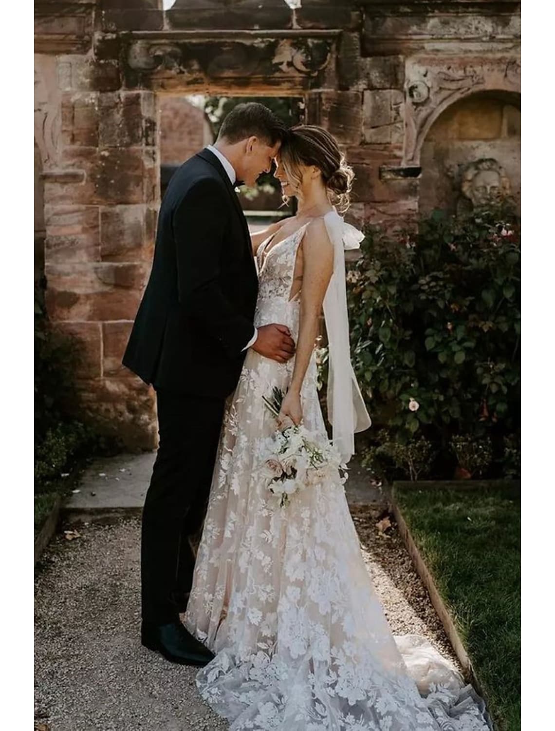 Side profile of an elegant mermaid V-neck long sleeve lace wedding dress.