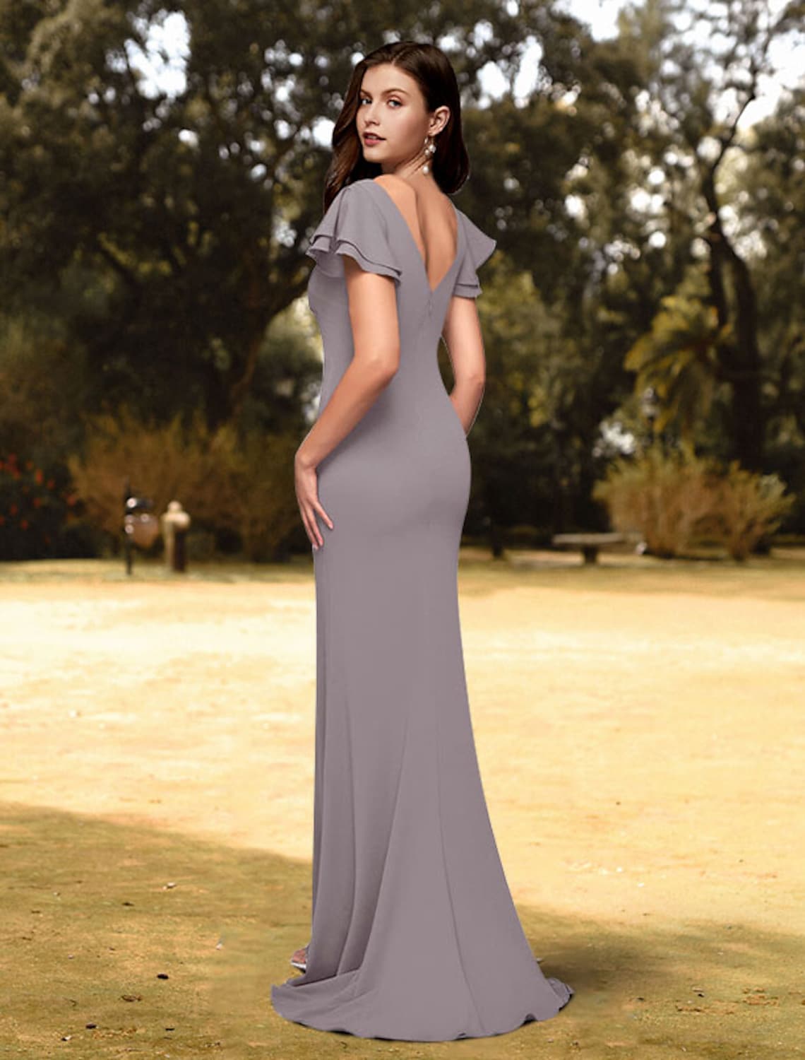 Back view of a woman in a sleek dark sheath evening gown with a sweep train.