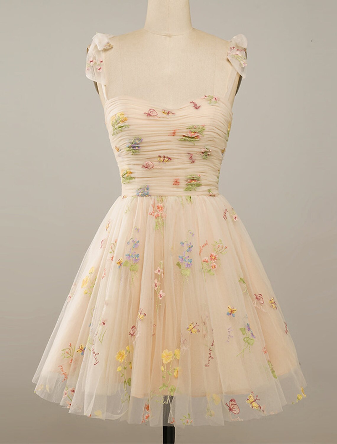 Close-up of the delicate floral embroidery on the tulle fabric of the A-line dress.