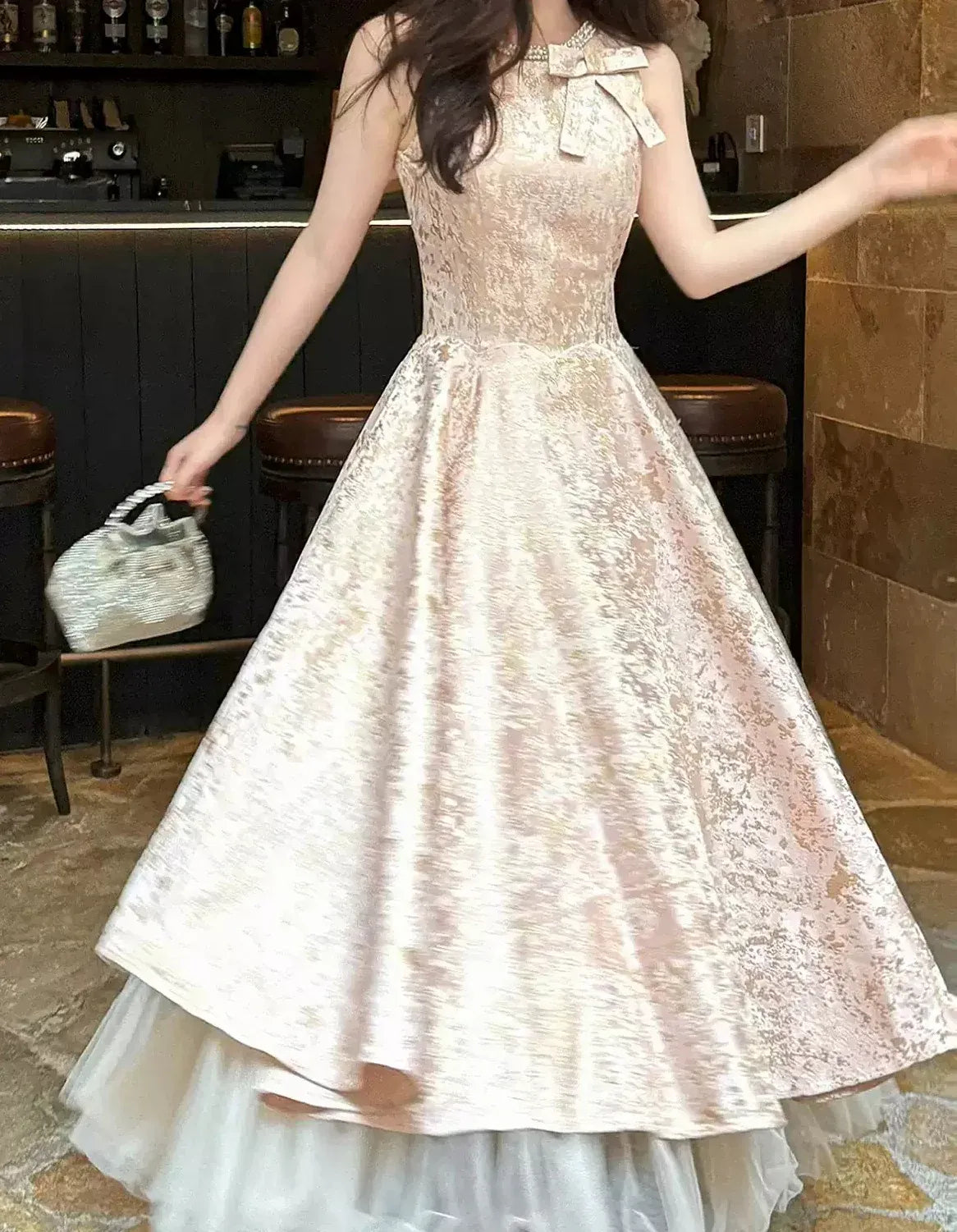 Elegant A-line champagne prom dress with halter bow neckline and jacquard bodice.