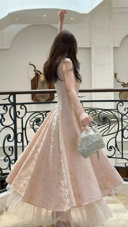 Close-up of champagne jacquard fabric and halter bow on a tea-length prom dress.