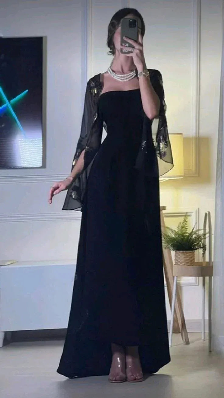 Model in elegant black strapless floor-length prom dress with embroidered bell-sleeve shrug.