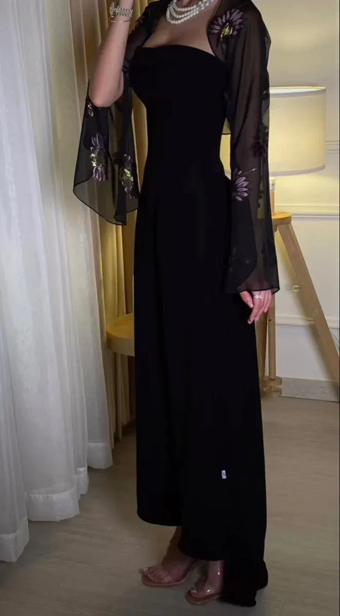 Elegant black strapless prom dress and sheer embroidered bell-sleeve shrug on a model.