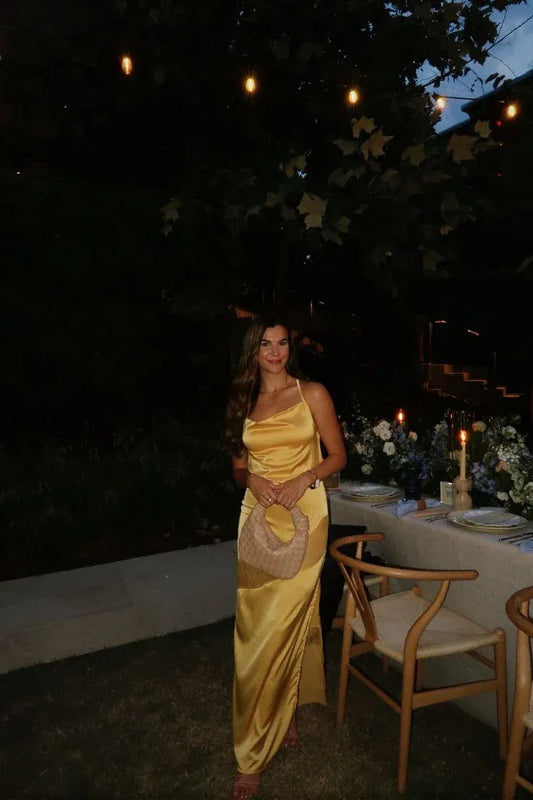 Elegant golden-yellow mermaid prom dress with cowl neck, spaghetti straps, and high slit.