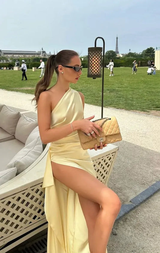 Elegant pale-yellow mermaid prom gown with one-shoulder neckline and high slit.