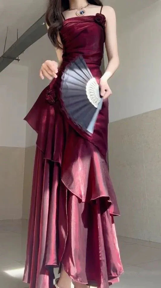 Side view of the burgundy mermaid prom dress, showcasing rose appliqués and tiered ruffles.