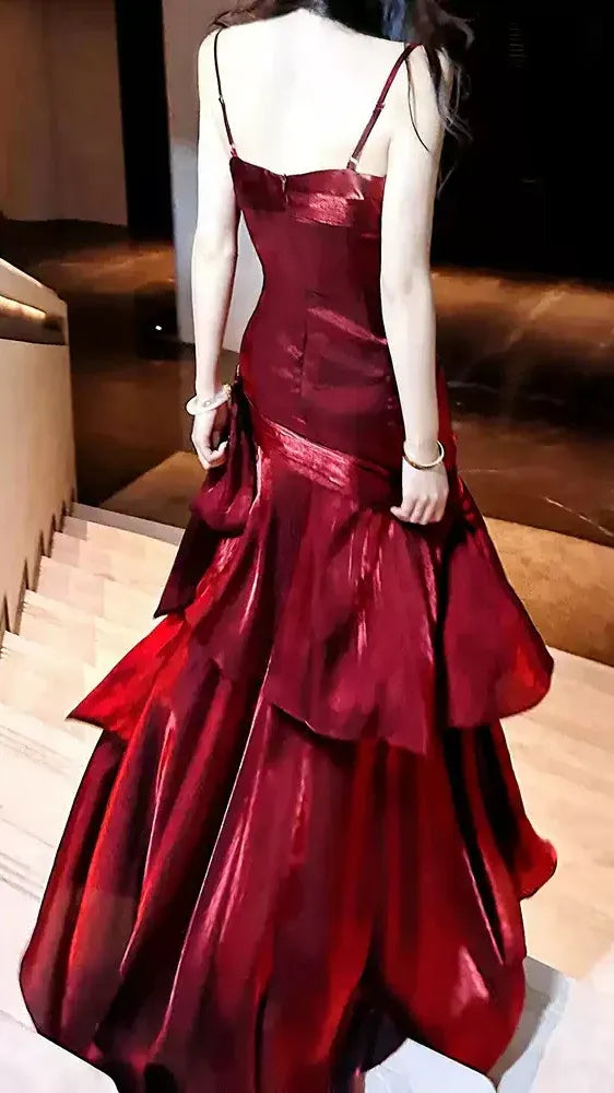 Back view of the elegant burgundy prom dress, showing the open back design and mermaid silhouette.