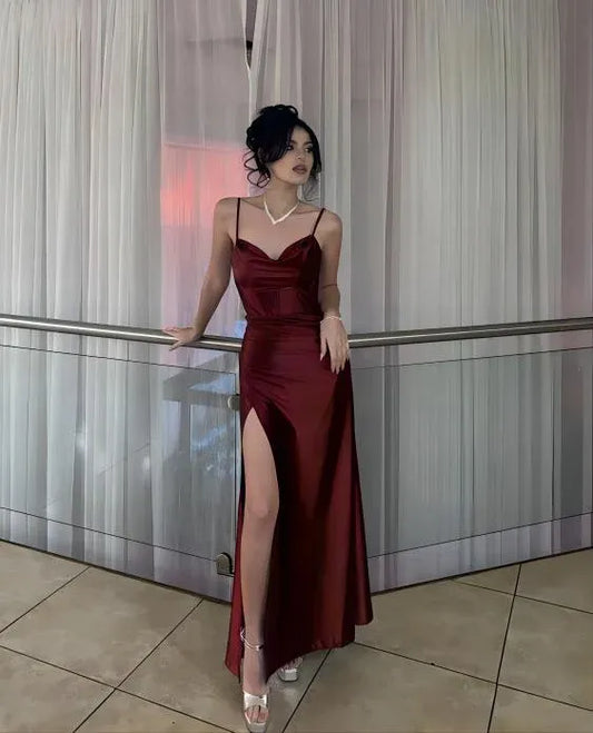 Elegant burgundy sheath prom dress with cowl neck, spaghetti straps, and a high front slit.