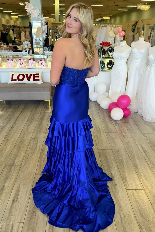 Elegant royal blue strapless mermaid prom gown with beaded corset and ruffled high-slit skirt.
