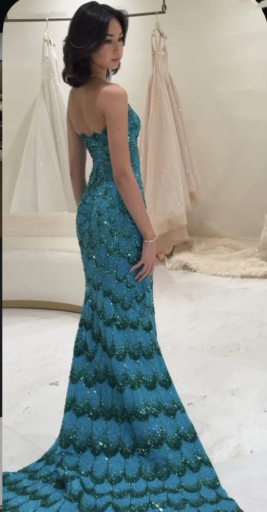 Full-length view of the glamorous peacock-teal sequin mermaid prom dress.