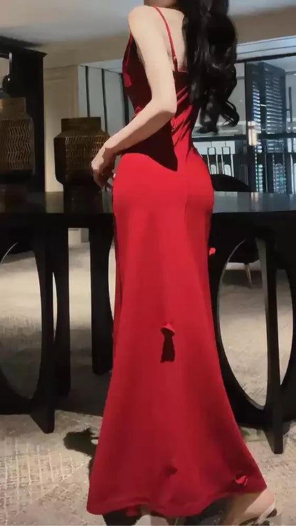 Side profile of model showcasing the red cowl neck prom dress and high slit.