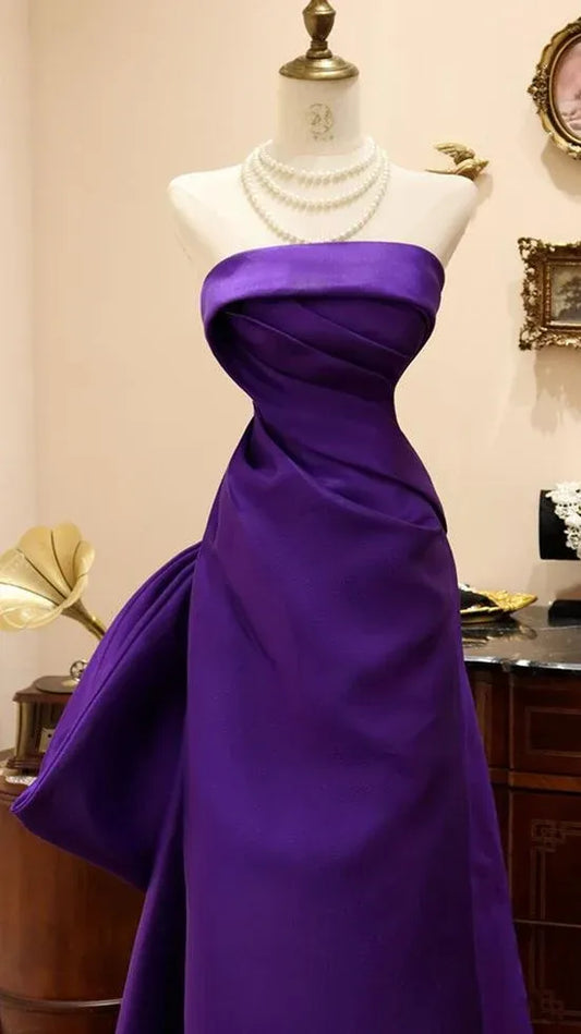 Back view of the royal purple mermaid prom dress, highlighting the oversized bow and corset back.