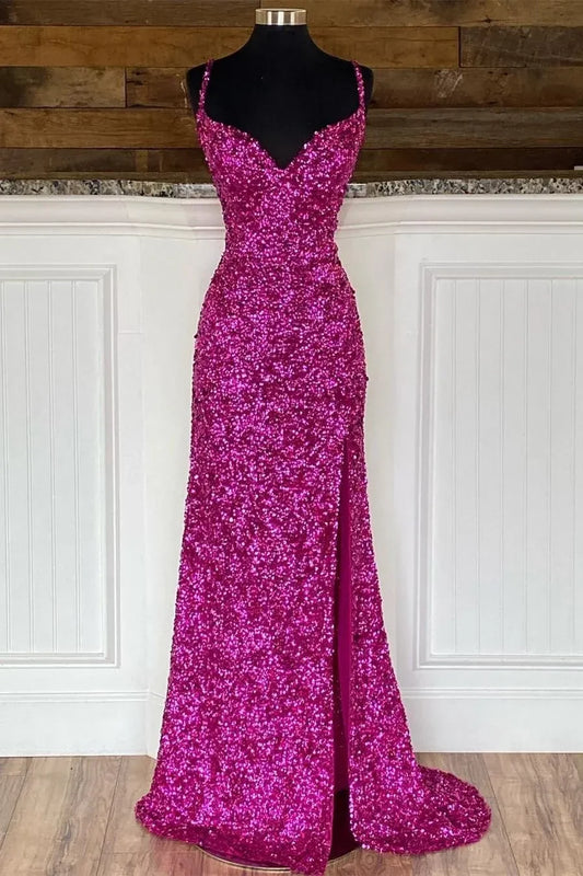 Model posing in a sparkling hot pink sequin mermaid prom dress with spaghetti straps and a high slit.