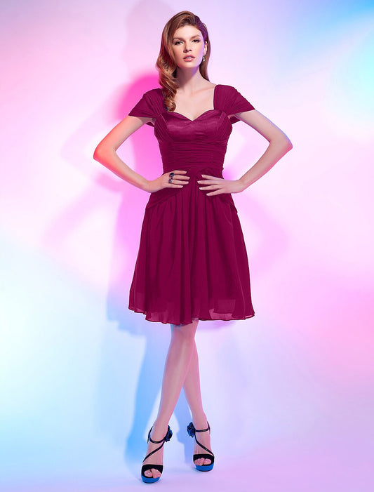 Model in a light pink A-line sweetheart short sleeve chiffon homecoming dress with draping.