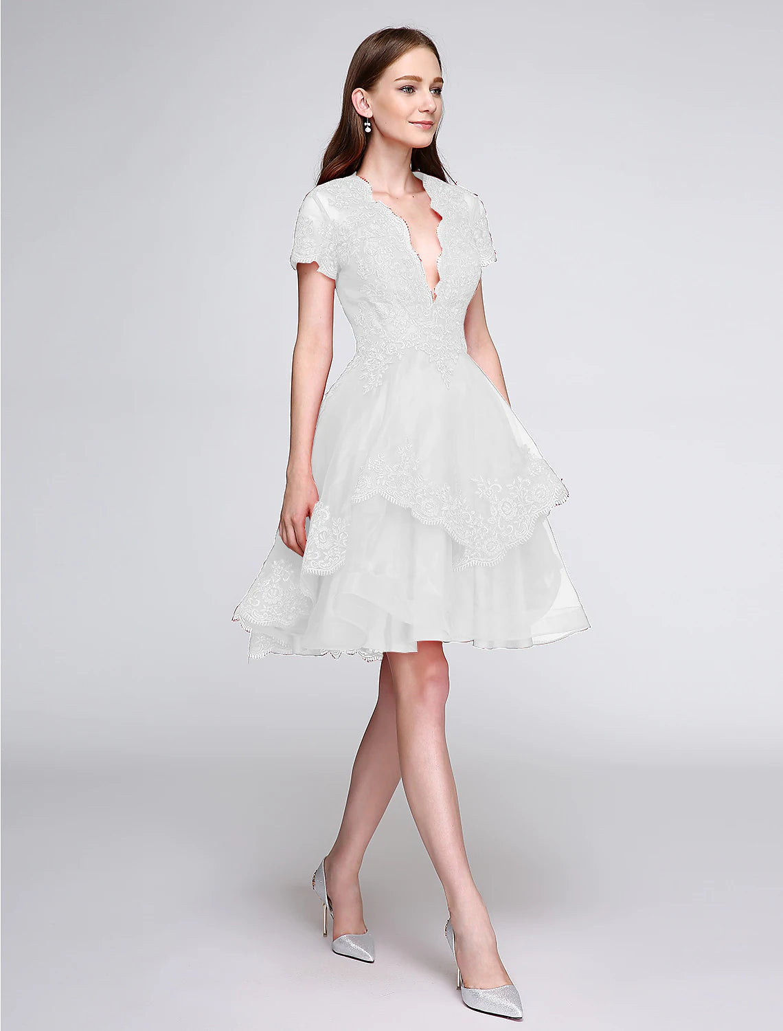 Elegant knee-length organza cocktail dress featuring a plunging neckline and short sleeves.