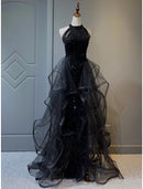 Woman wearing a dazzling A-line halter sequined prom dress with a sweep train.