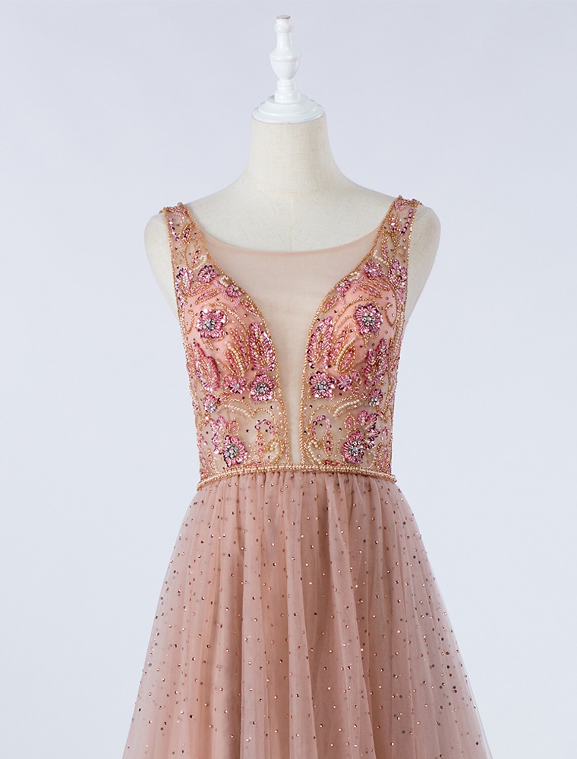 Back view of the elegant A-Line silver prom gown with illusion neck and beading.