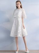 Elegant A-line dark blue cocktail dress with jewel neck and half sleeves, featuring vintage lace detail.