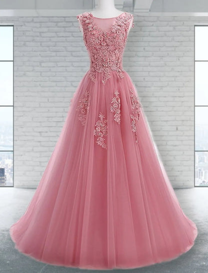 Close-up of the jewel neck and intricate appliques on a tulle prom dress.
