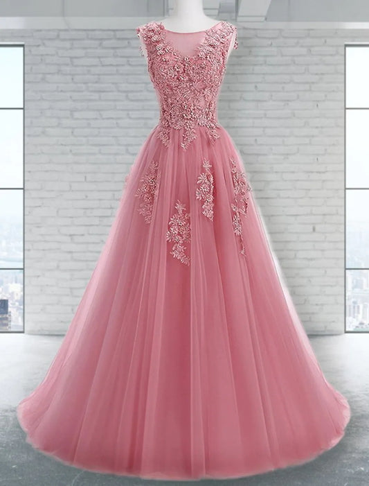 Close-up of the jewel neck and intricate appliques on a tulle prom dress.