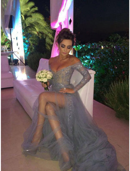 Model posing in the white A-line off-shoulder long sleeve chiffon gown, highlighting the delicate lace insert.