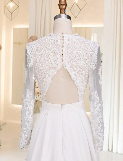 Close-up of V-neck bodice, long sleeves, and appliques on satin wedding dress.