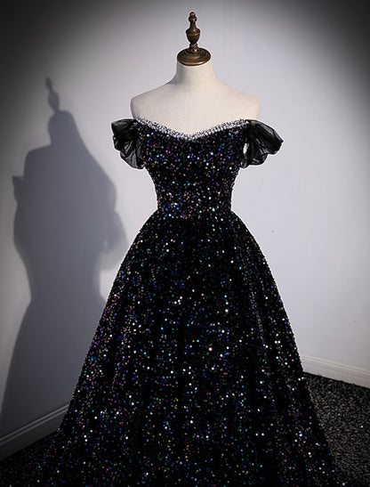 Side profile of a pleated sequined off-shoulder ball gown.