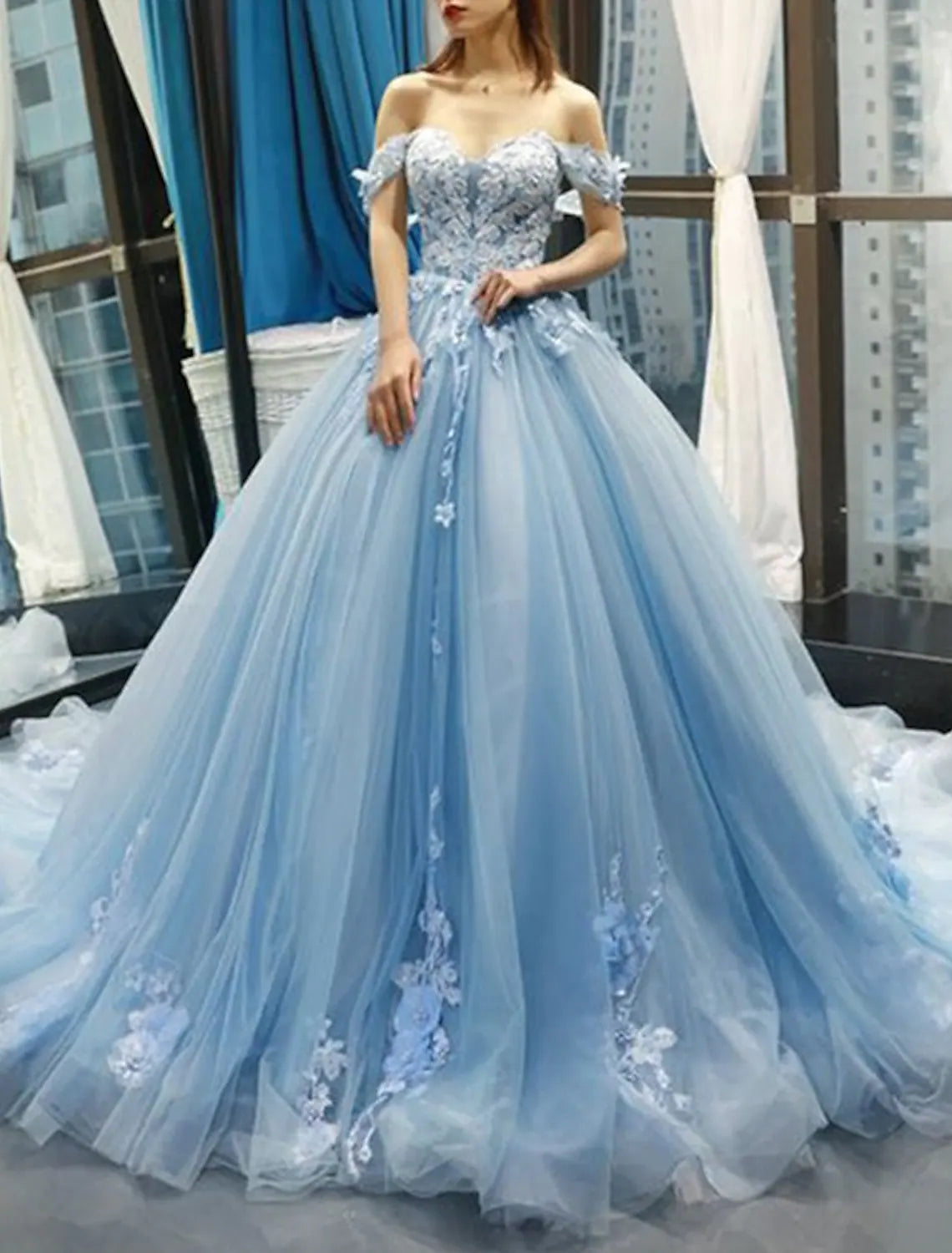 Elegant light blue ball gown quinceanera dress with sweetheart neckline and floral lace.