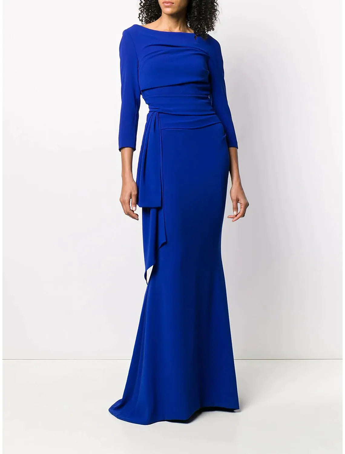 Woman posing in a side view of a scoop neck mermaid trumpet formal dress.