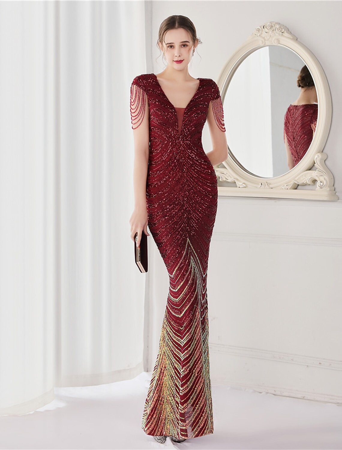 Model showcasing the floor-length sequined mermaid gown from the side.