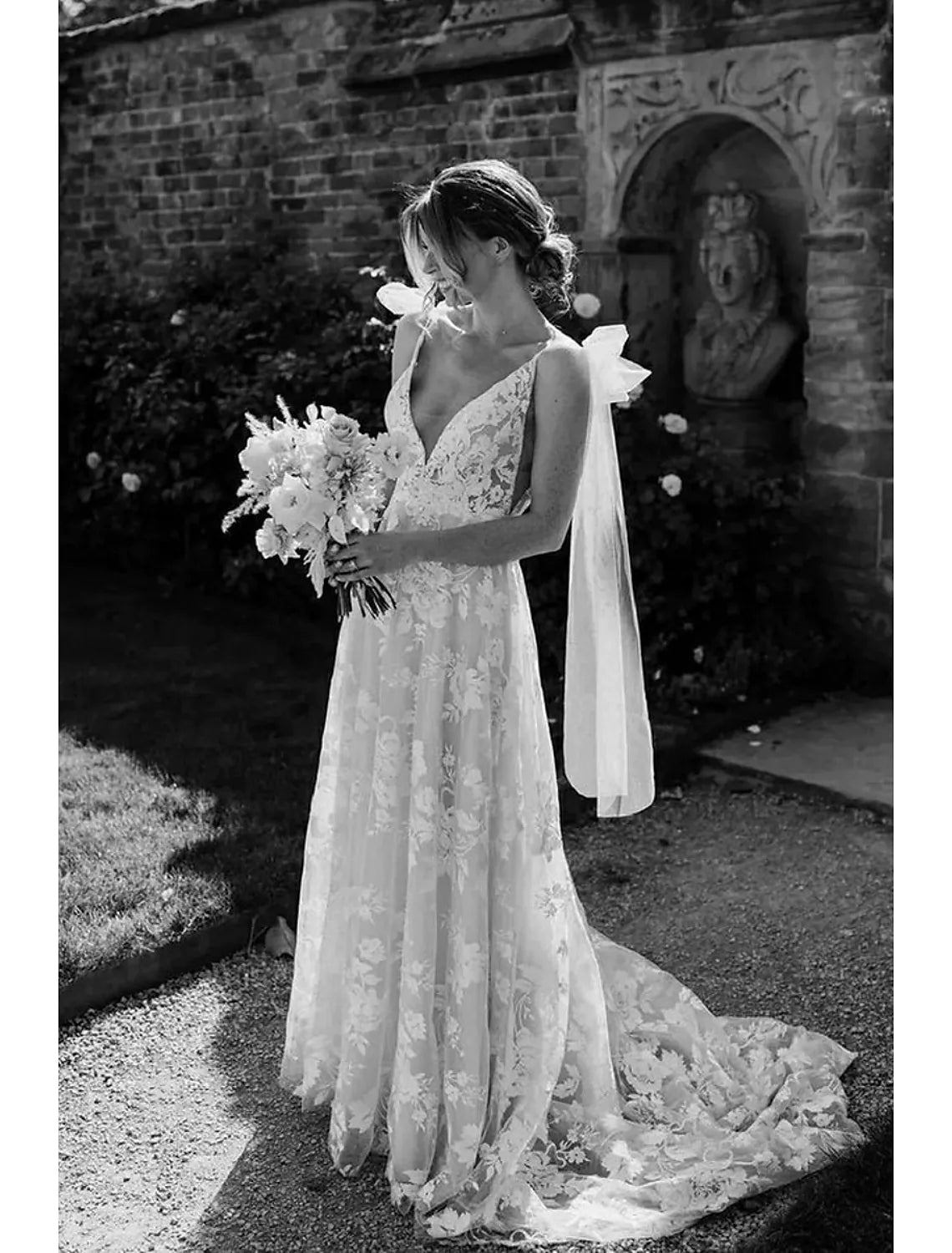 Front view of an elegant mermaid V-neck long sleeve lace wedding dress with appliques.