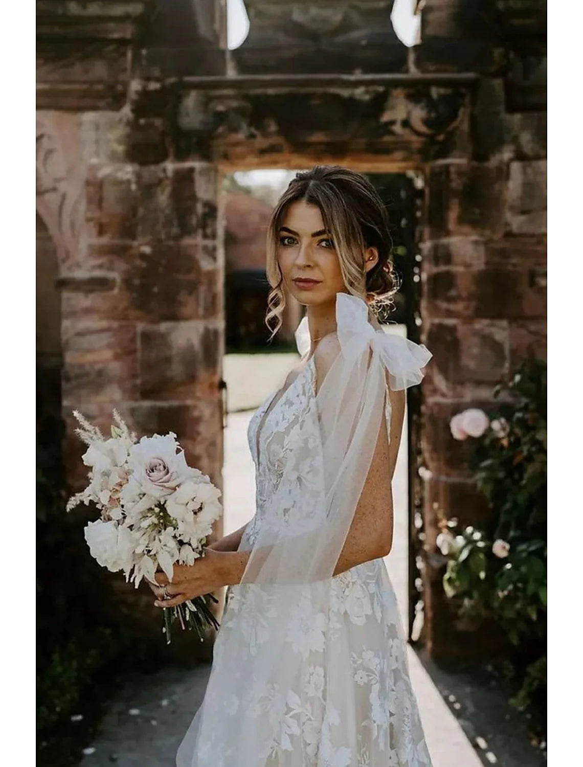 Back view of a mermaid V-neck long sleeve lace wedding dress, showcasing the sweep train.
