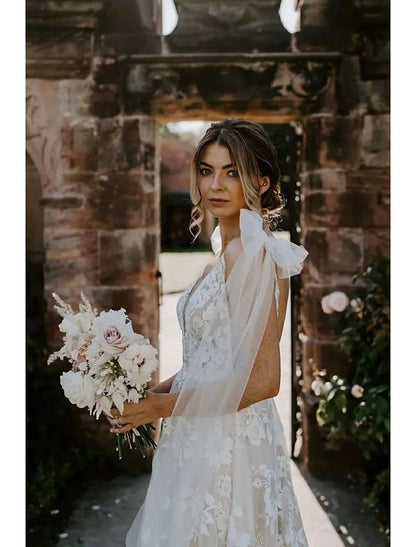 Back view of a mermaid V-neck long sleeve lace wedding dress, showcasing the sweep train.