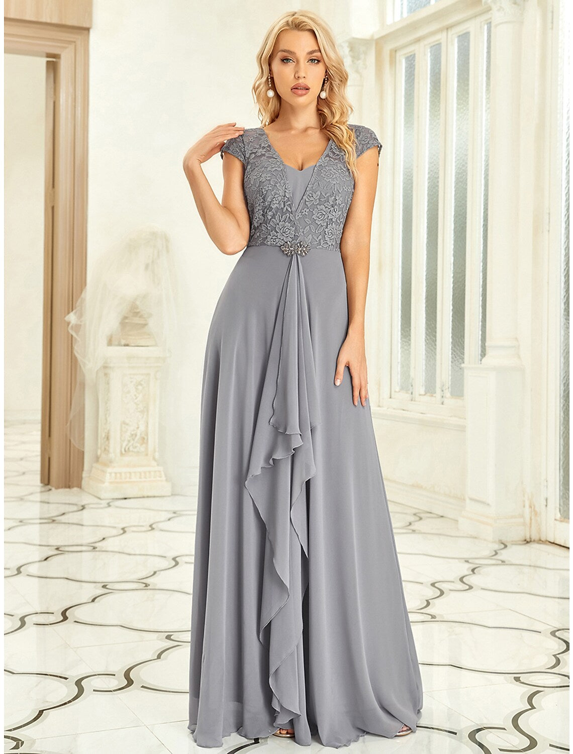 Full length view of a pleated off-shoulder prom dress with sweep train.