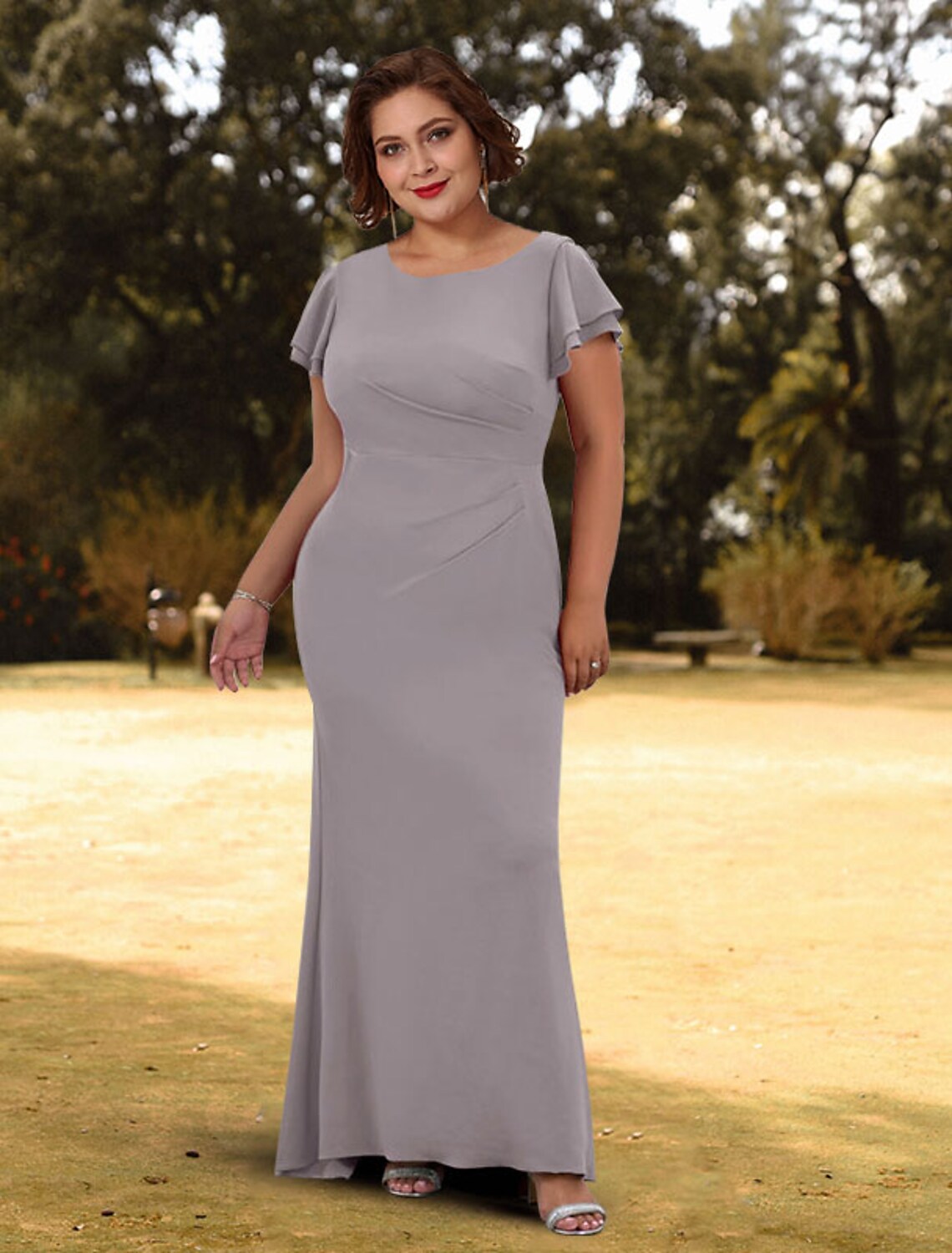 Woman wearing a sleek dark sheath evening gown with short sleeves and a jewel neck.
