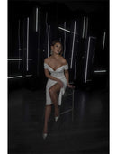 Woman in sparkling white sequined off-shoulder tea-length bachelorette dress.